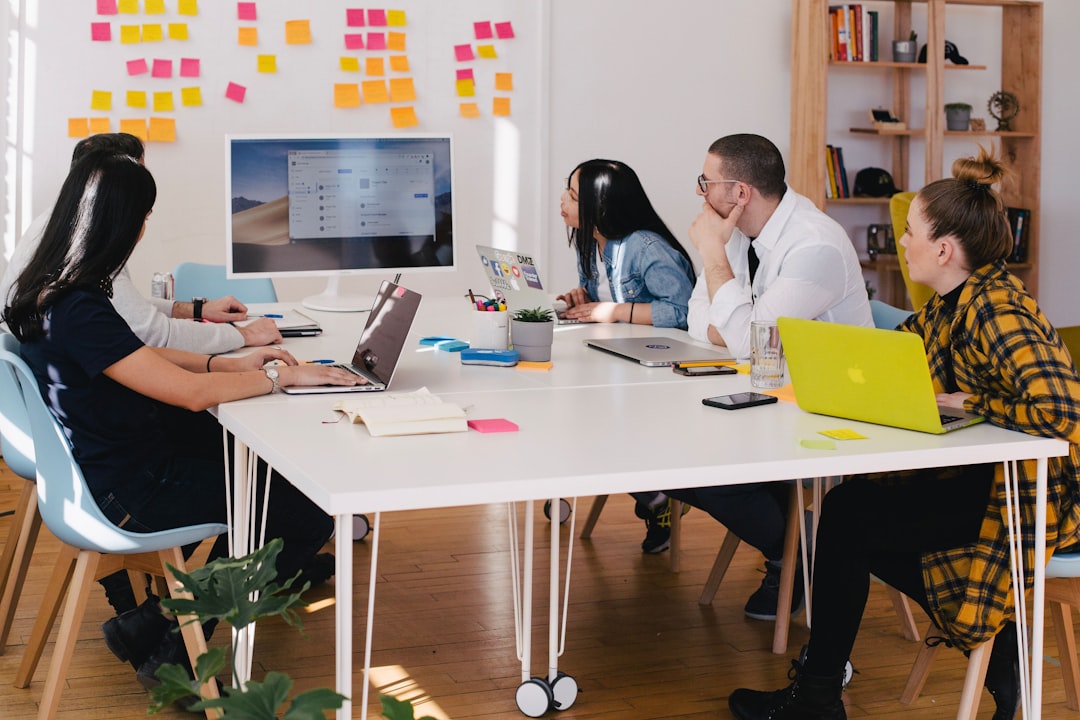 five-person-by-table-watching-turned-on-white-imac-vbxyfxlgpjm